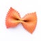Colored bow tie pasta. Closeup single orange farfalle on white background