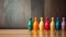 Colored bowling pins in a row on wooden floor