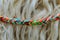 Colored braided cord on blurred sheep wool background