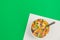 Colored breakfast cereal in a bowl on a green background, flat lay.