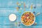 Colored breakfast cereals in a bowl and milk on a blue wooden background.