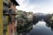 Colored buildings overhanging a river with blue sky by day