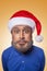 The colored caricature of the funny santa clause with big head and blue shirt, red hat with gray beard, surprised looking