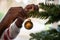 Colored child hanging golden holiday bauble on christmas tree