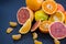 Colored Citrus fruits on a dark blue background. Slices of citrus and peel. Citrus reticulata. Citrus paradisi. Citrus limon