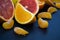 Colored Citrus fruits on a dark blue background. Slices of citrus and peel. Citrus reticulata. Citrus paradisi. Citrus limon