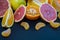 Colored Citrus fruits on a dark blue background. Slices of citrus and peel. Citrus reticulata. Citrus paradisi. Citrus limon