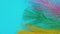 Colored decorative multicolor feathers on a blue background close-up.