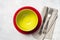 Colored dinnerware - plate, cutlery and napkin on light stone ta