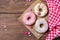 Colored donuts, sprinkles hearts and smarties, wooden background