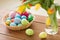Colored easter eggs in basket and flowers at home