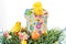 Colored Easter eggs, chicks, candy and bucket on grass