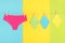 Colored eco reusable menstrual pads and underpants on washing line, bright background. Health care and zero-waste, no