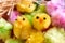 Colored fake easter chicks and raffia nest materia