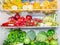 Colored full fridge with fruit and vegetables