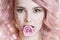 Colored hair. Beauty women portrait of young curly woman with pink hair, perfect art make-up with glitter. Rose in her