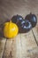 Colored halloween pumpkins on wooden desk. Difference. Alone among the others. Single orange pumpkin in a row of black pumpkins