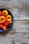 Colored halved plate of imperfect tomatoes over old wooden table