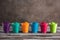 Colored holi powders in plastic cups on a wooden old table. Holi festival selective focus
