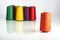 Colored industrial spools arranged on white background