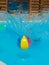 A colored inflatable ball in the pool with splashes.