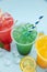 Colored lemonades in plastic cups with ice, fruits and berries