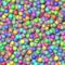 Colored little balls randomly scattered on the seamless background - top view