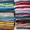 Colored multi-colored T-shirts lie in a stack. Concept of diversity in the world