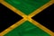 Colored national flag of the modern state of Jamaica on beautiful pleated silk fabric, concept of tourism, economic and political