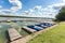 Colored old vintage plastic catamarans and boats near a wooden pier on the shore of a large lake