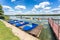 Colored old vintage plastic catamarans and boats near a wooden pier on the shore of a large lake