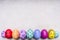 Colored ornamental eggs for Easter with painted faces border ,place for text wooden rustic background top view close up