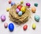 Colored ornamental eggs for Easter with painted faces lie in a nest wooden rustic background top view close up