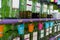 Colored pails hanging on taps of perfume bottles on shelves