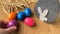 Colored painted eggs rotate on a wooden table against a background of ripe ears of wheat, Easter concept