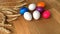 Colored painted eggs and wheat ears lie on a wooden table, easter concept