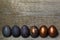Colored painted pearl chicken Easter eggs of violet, golden color on a old wooden background, Easter holiday, copy space