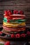 Colored pancakes with fruit, almonds and powdered sugar