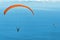 Colored paragliders above blue ocean