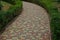 Colored paving alley among green bushes and vegetation