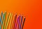 Colored pencil group isolated on orange. Horizontal background