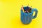 Colored pencils in a bucket on yellow background. Back to scool concept