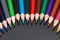 Colored pencils in close up for school and arts semicircular arranged with dark background and copy space for free text