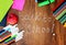 Colored pencils, felt-tip pens and markers, notebooks, stickers a red apple on the wooden background with the back to school insc