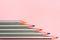 Colored pencils on pastel pink background. Trend colors, Pattern.Multi-colored wooden pencils with silvery coating