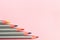 Colored pencils on pastel pink background. Trend colors, Pattern.Multi-colored wooden pencils with silvery coating
