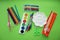 Colored pens,pencils, paints, pens for writing. Colorful items for school, office on a green background