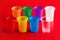 Colored plastic glasses on red background