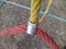 colored rope cables fastened together with a metal fastener