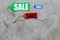 Colored sale labels on light stone background top view copyspace